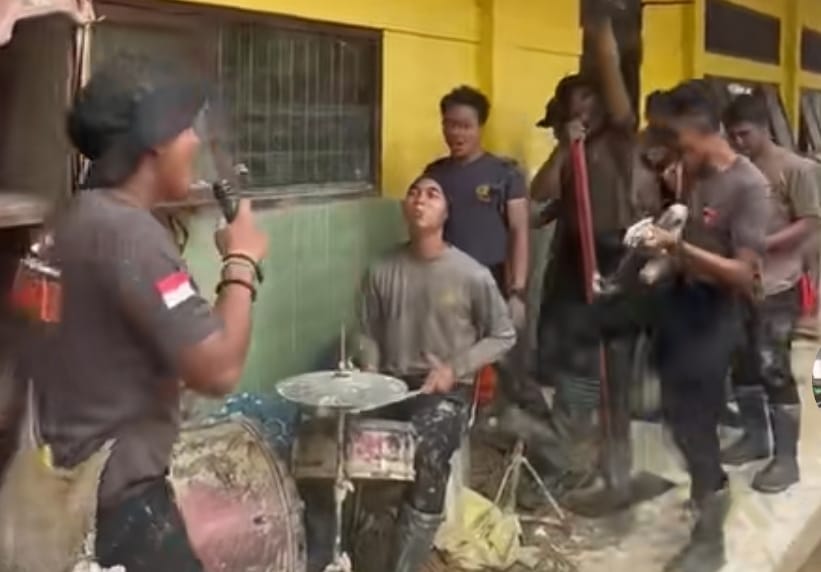 Anggota Brimob menyanyikan lagu Dewa 19 di sela kegiatan bersama warga di Aceh Tamiang. (Instagram/humas.brimob.aceh)
