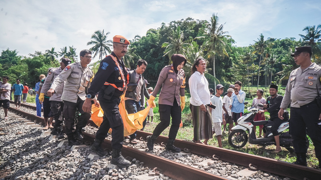 EVAKUASI: Kapolsek Kalisat Iptu Ika Mufid Dati bersama anggota Polsus dan warga mengevakuasi korban kecelakaan yang tertabrak KA Logawa, Jumat (9/1).