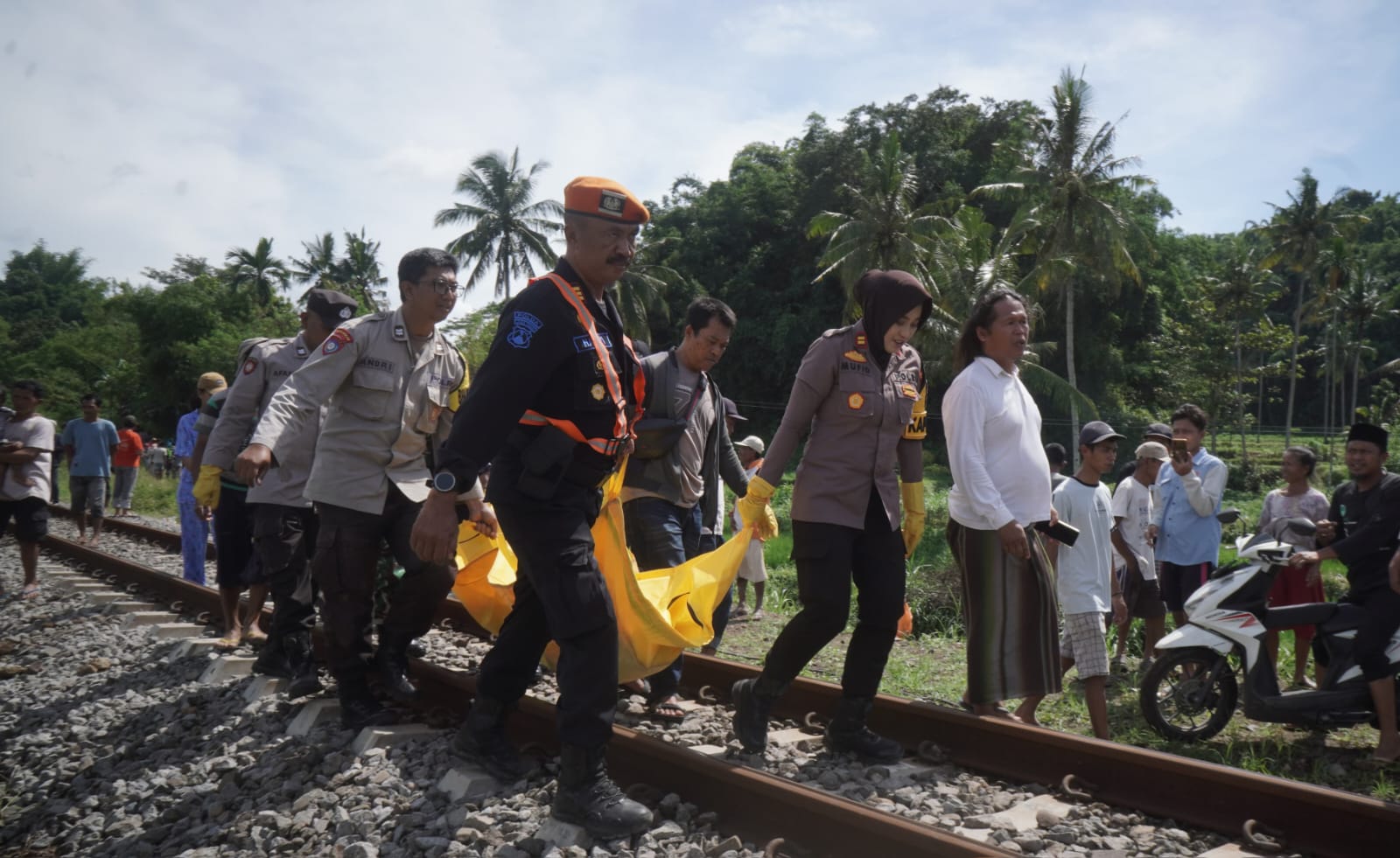 PROSES EVAKUASI: IPTU Ika Mufid Dati Kapolsek Kalisat saat mengevakuasi korban yang meninggal tertemper KA Logawa bersama anggota Polsus dan warga pada Jumat (9/1/2026) pukul 09.20 wib.