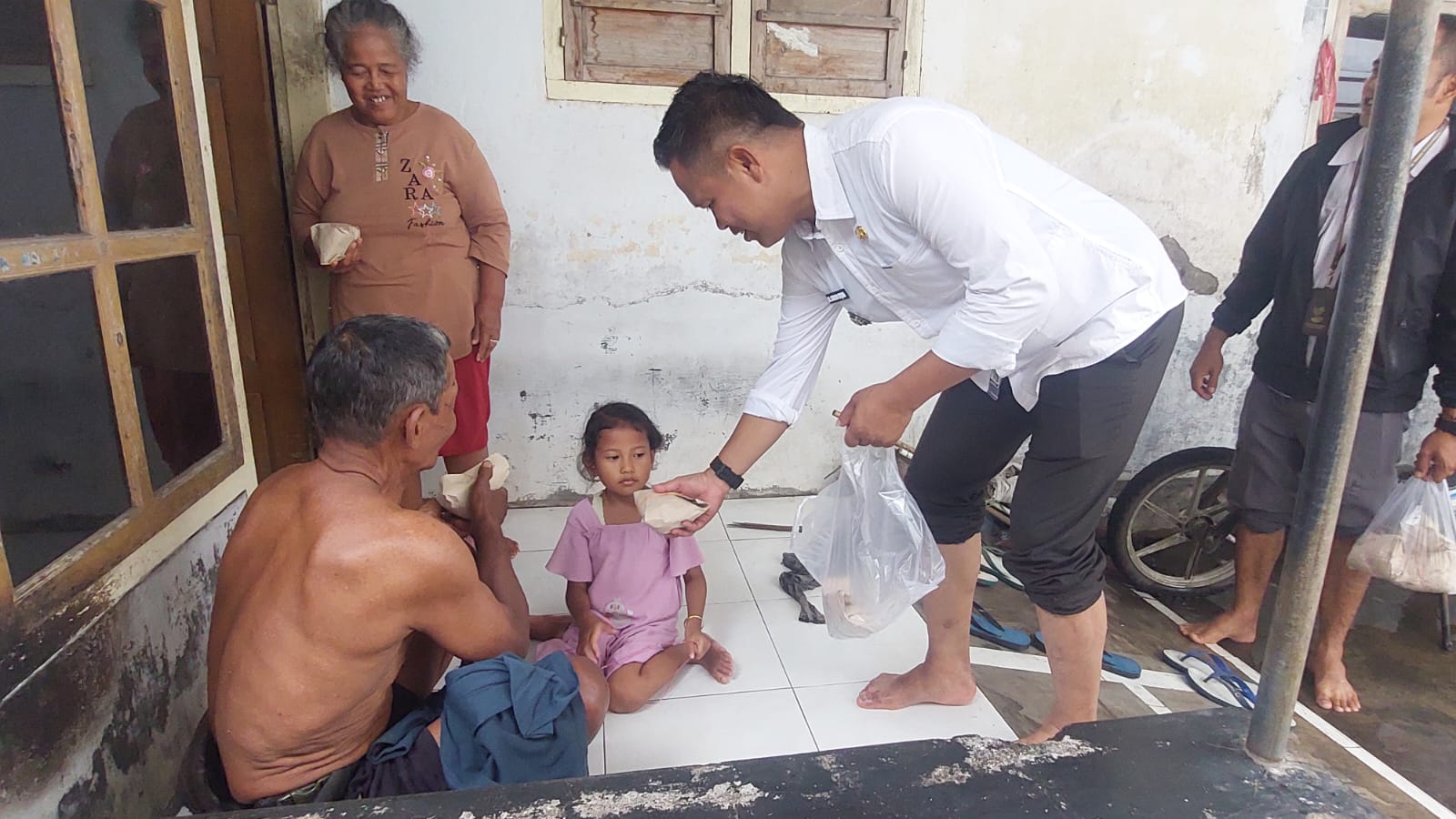 SERAHKAN NASI SIAP SAJI: Mohammad Soleh, Kepala Desa Lojejer, Kecamatan Wuluhan, Jember bersama Babinsa dan perangkat Desa saat menyerahkan nasi siap nasi kepada warga yang terdampak banjir pada Rabu