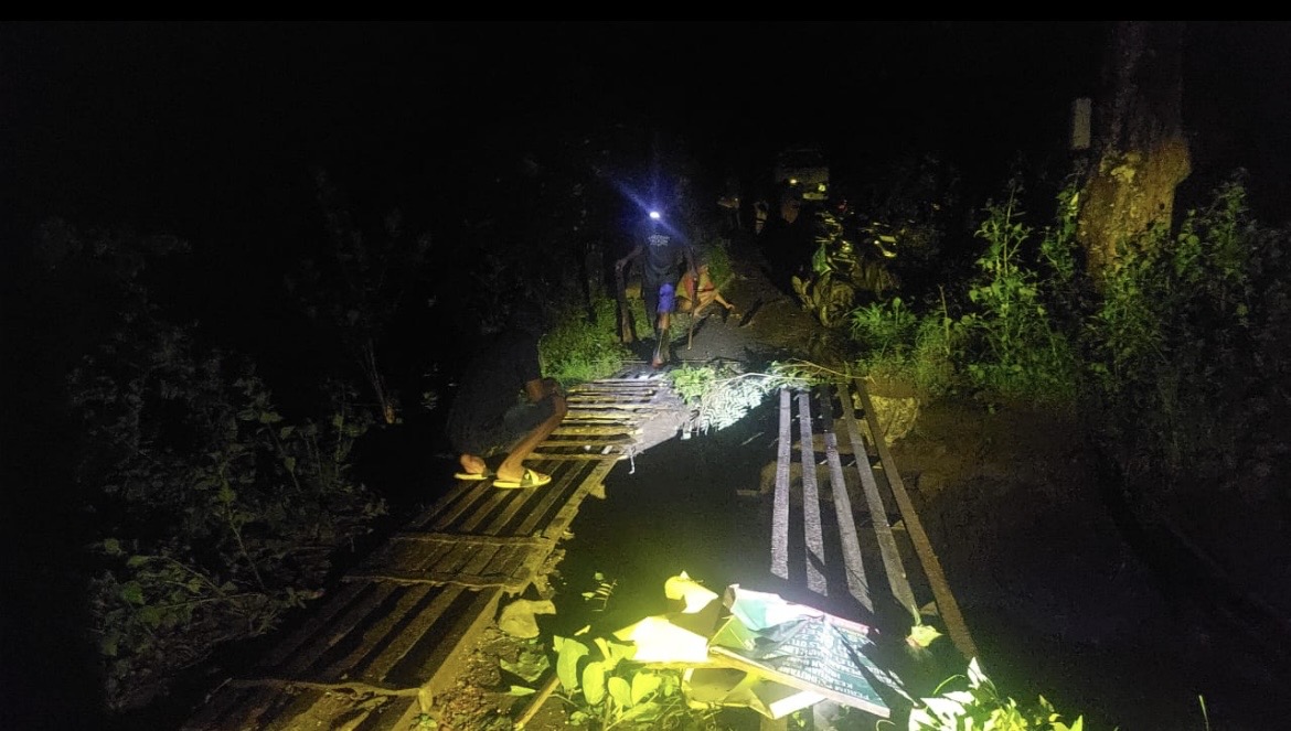 MENDATANGI: Petugas saat meninjau lokasi jembatan ambrol akibat cuaca ektrem, kemarin (13/1).(BPBD BONDOWOSO FOR RADAR IJEN)