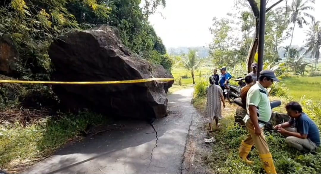 NUTUPI JALAN: Batu berukuran 3 meter X 4 meter yang jatuh dari atas gumuk di Dusun Krajan 2, Desa Sukoreno, Kecamatan Kalisat, Jember menutupi jalan desa pada Jumat (16/1/2026) pukul 15.00 wib