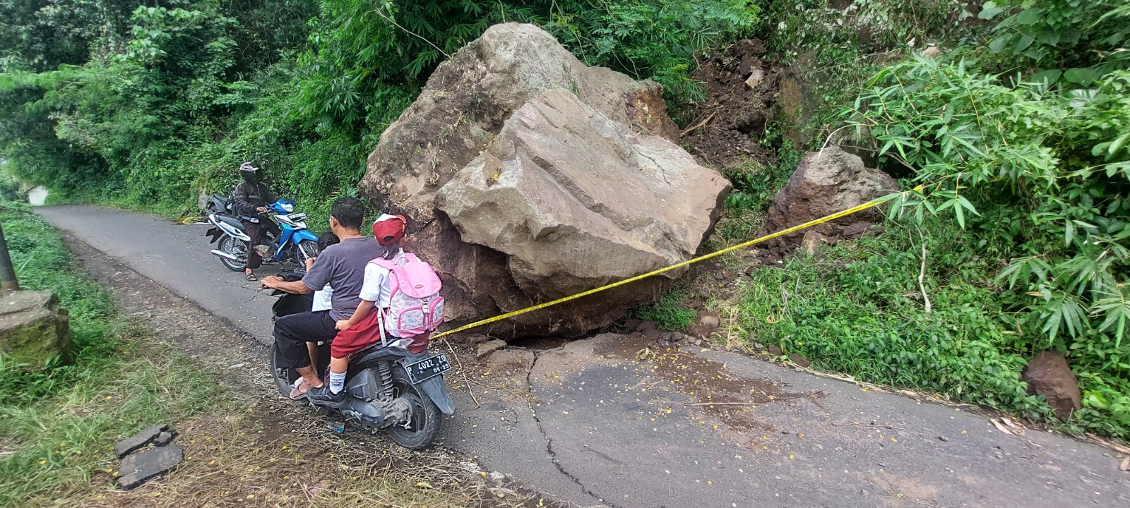 DI TENGAH JALAN: Batu besar menutupi jalan penghubung Desa Sukorejo dan Desa Gumuksari, Kecamatan Kalisat. Hingga, kemarin (19/1) batu tersebut tidak kunjung dievakuasi.