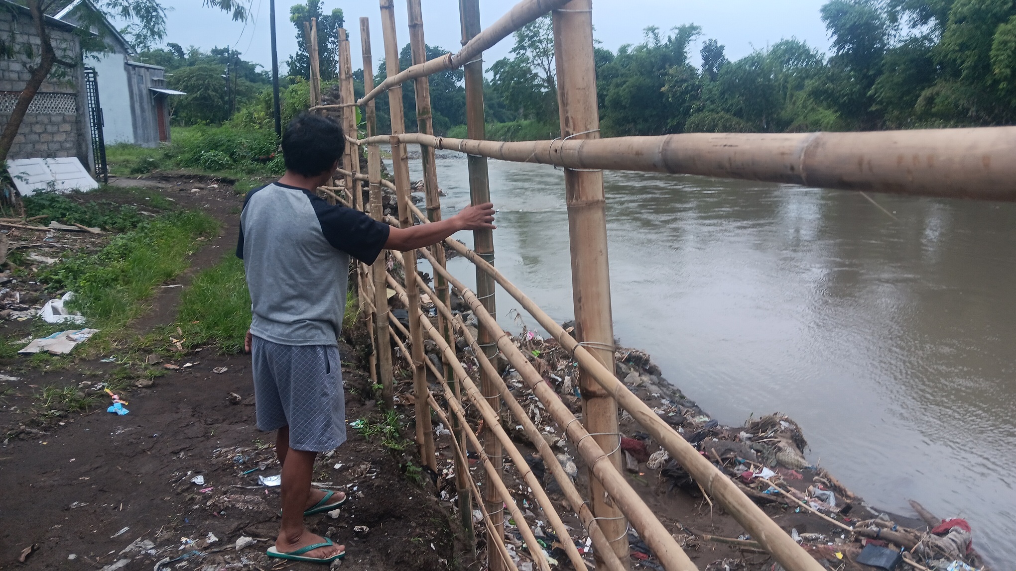 DIPAGAR BAMBU: Warga di Perum Villa Istana Tegal Besar menatap Sungai Bedadung yang bisa tiba-tiba meluap saat hujan deras datang.