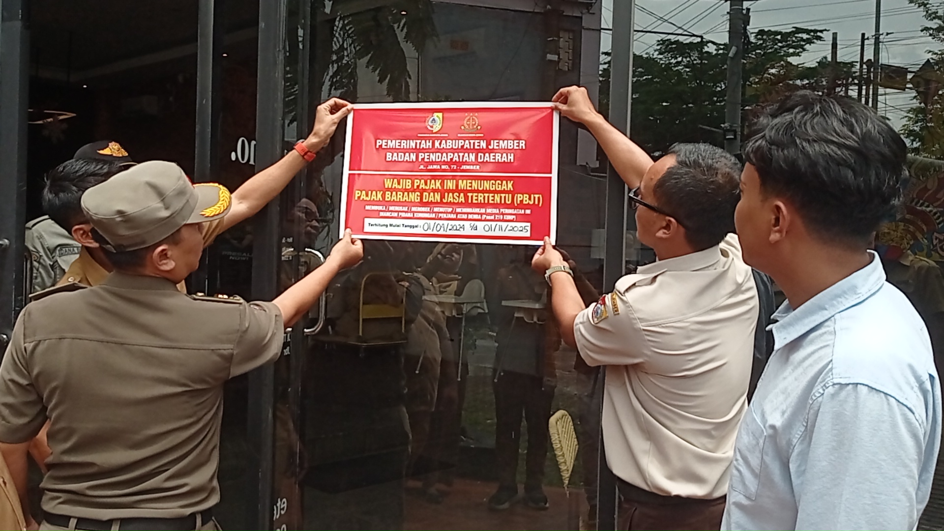 DIPASANG:&nbsp;Petugas memasang stiker penunggak pajak di Eterno Cofee and Eatery di Sumbersari pada 22 Desember lalu. Ternyata sekarang stiker itu tidak ada.&nbsp;