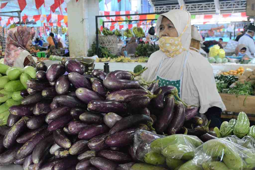 MENUNGGU: Seorang penjual kebutuhan pokok di pasar induk menunggu pembeli.(FAQIH HUMAINI/RADAR IJEN)
