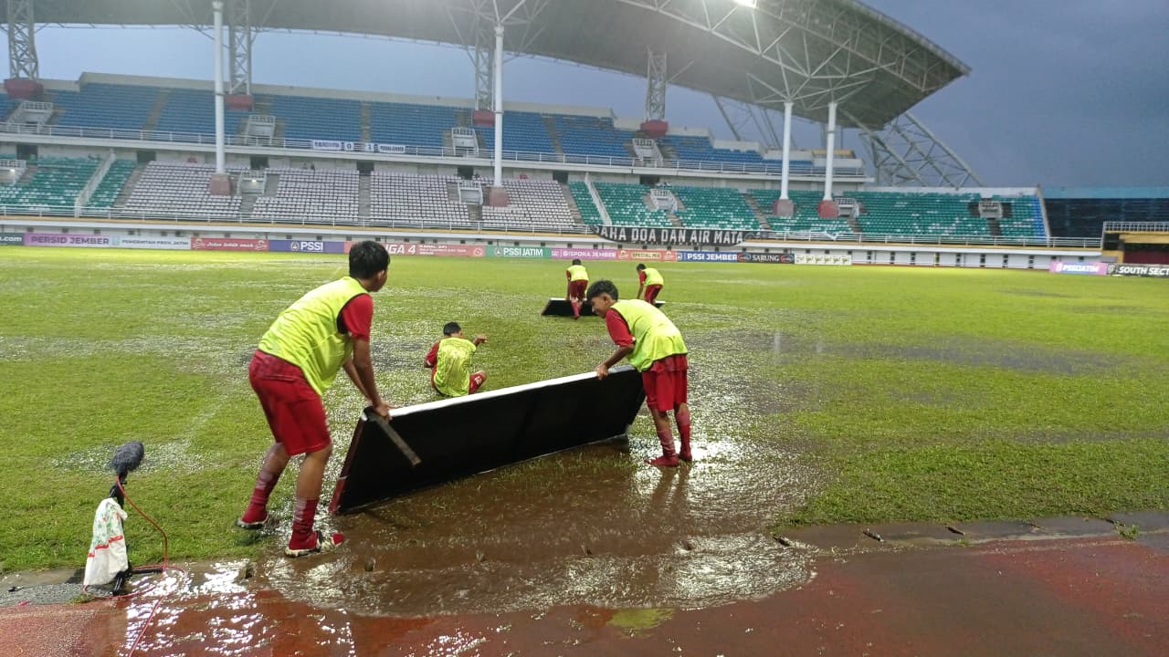 TERGENANG: Sejumlah ball boy pada laga kemarin mencoba menyingkirkan genangan air di JSG. Hujan dari siang hari hingga sore membuat dua pertandingan molor.