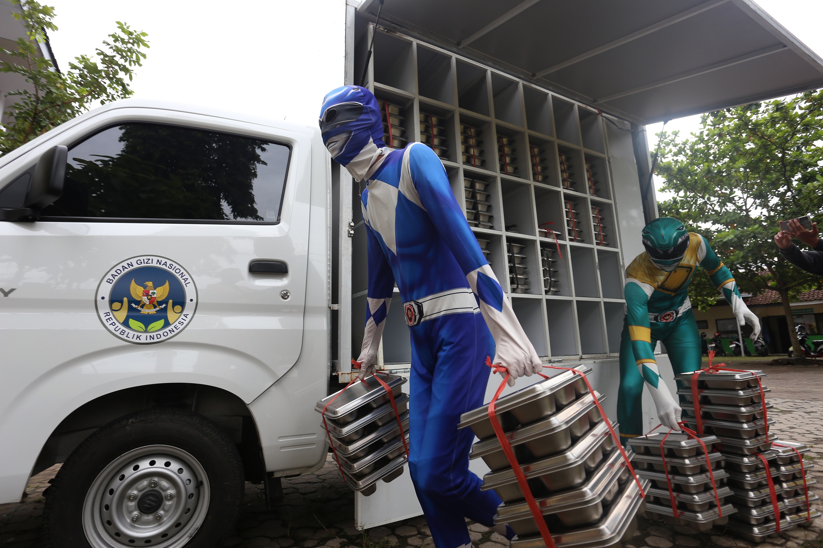 SUPERHERO KE SEKOLAH: Petugas SPPG mengenakan kostum Power Rangers mendistribusikan MBG kepada siswa SDN Kebonsari 05 dan SDN Kebonsari 02, kemarin pagi.