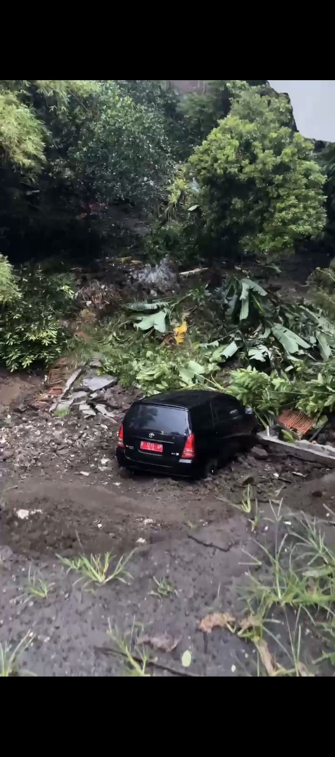 Mobil operasional Diskominfo yang terperosok ke sungai, saat diparkir, di area Gedung Balai Serba Guna Kaliwates, Jember, Rabu (21/01/2026) petang. (Diskominfo/Tangkapan layar video)