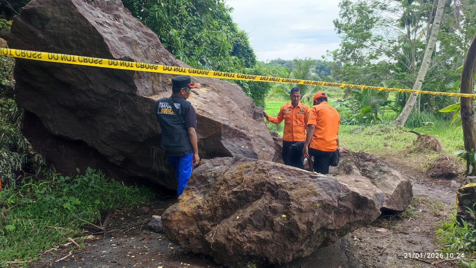 BUTUH WAKTU LAMA: Personel BPBD Jember saat meninjau batu longsoran berukuran besar di Desa Sukoreno, Kalisat.