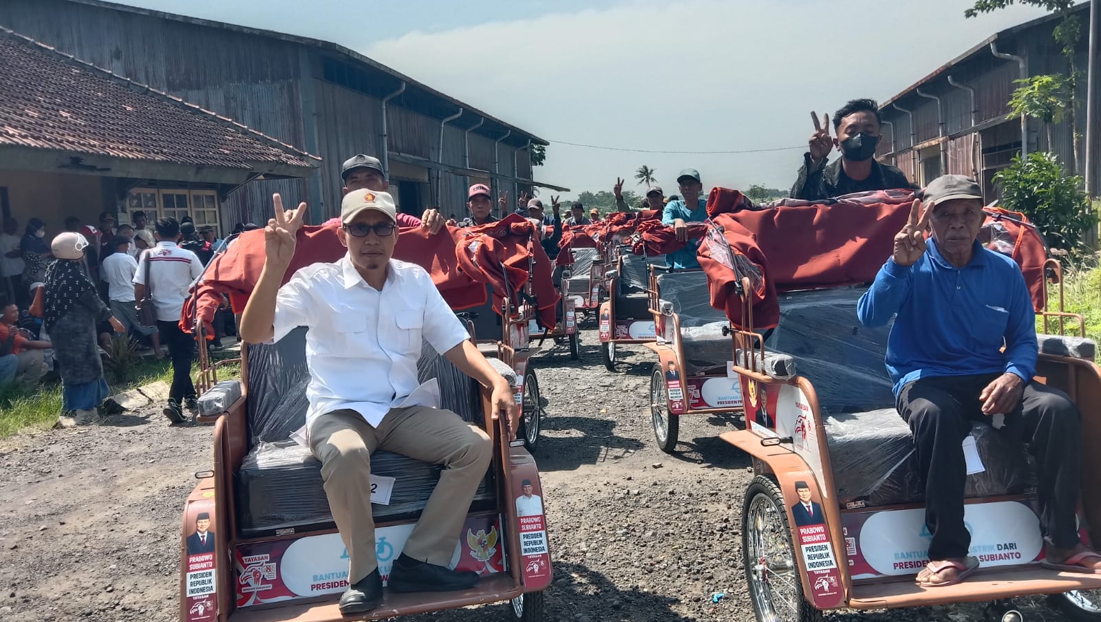 MENYERAHKAN: Abdul Majid (kiri) bersama abang becak dalam pemyerahan bantuan becak listrik (FAQIH/RJ)