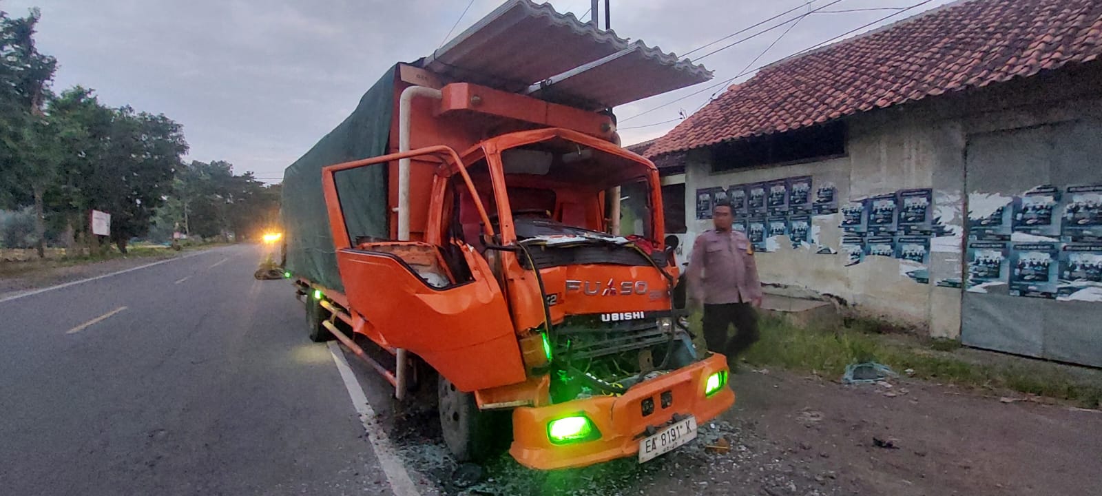 RUSAK PARAH: Anggota Polsek Sumberbaru saat mendatangi lokasi kecelakaan truk Fuso yang mengalami kecelakaan di Jalan Nasional Jember - Surabaya di Desa Pringgowirawan, Sumberbaru, Jember