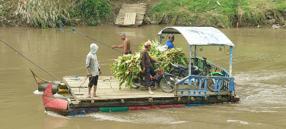 JALAN TERAKHIR: Petani jagung kembali memanfaatkan getek untuk menyebrang Sungai Kalimayang, Desa Andongsari, Kecamatan Ambulu, kemarin (21/7).