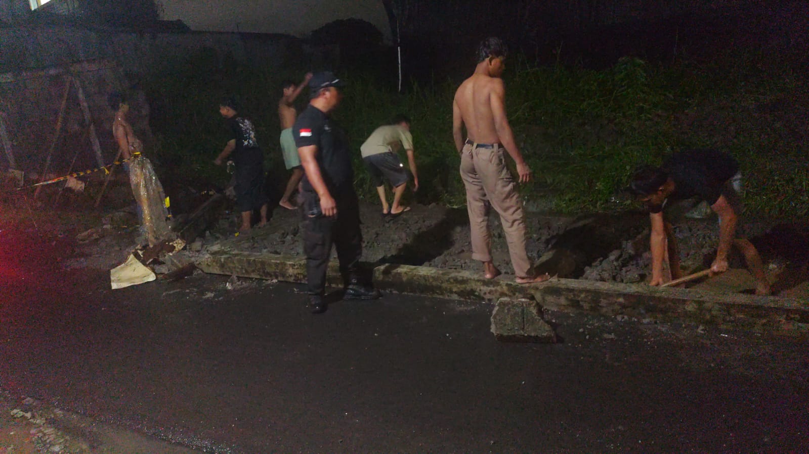 Tim gabungan  Polije dan Warga sekitar membersihkan materiall tembok yang roboh akibat diterjang banjir pada Rabu (28/1). (Humas Polije)