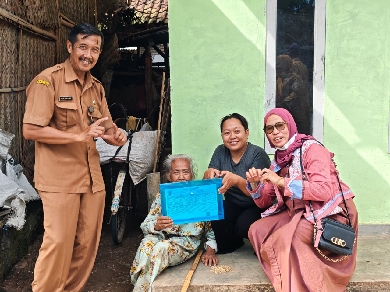 BERI LAYANAN SEPENUH HATI: Salah seorang penduduk lansia di Kecamatan Tanggul ketika menerima berkas adminduk KTP dari pihak kecamatan.