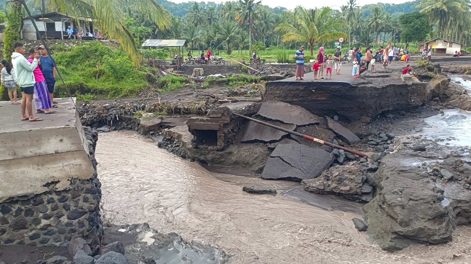 DIPERBAIKI: Sejumlah warga saat melihat kondisi tanggul yang terkikis banjir lahar Gunung Semeru, kemarin.(ROHMAN FOR RAME)