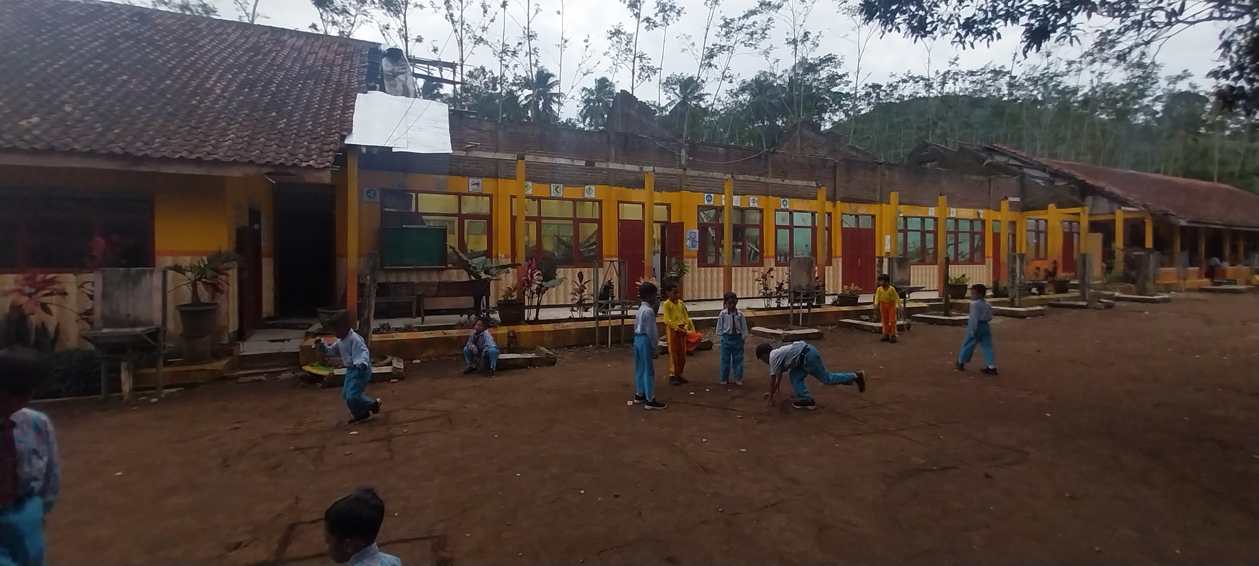 SEMANGAT BELAJAR: Pelajar SDN Kaliglagah 03 berolahraga dengan latar bangunan sekolah yang membutuhkan perbaikan.