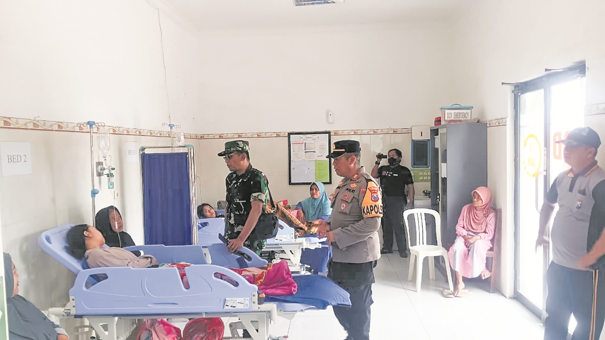 DIPANTAU: Anggota TNI dan polisi yang tergabung dalam Satgas Pengentasan Kemiskinan dan Suksesi MBG tingkat kecamatan memantau kondisi siswa SMPN 1 Umbulsari yang dirawat di Puskesmas Umbulsari.