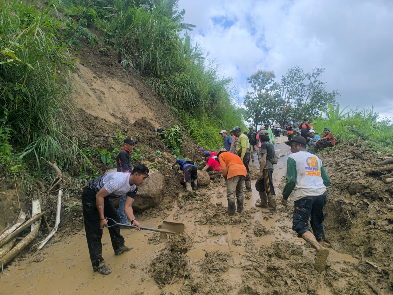 DITANGANI: Tim gabungan bersama warga gotong royong melakukan pembersihan material tanah longsor yang menutup jalan di Dusun Baban Barat, Desa Harjomulyo, Kecamatan Silo, kemarin.