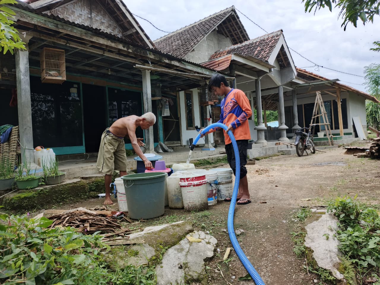 DISALURKAN: Petugas BPBD Bondowoso saat mendistribusikan air bersih kepada warga teedampak longsor.