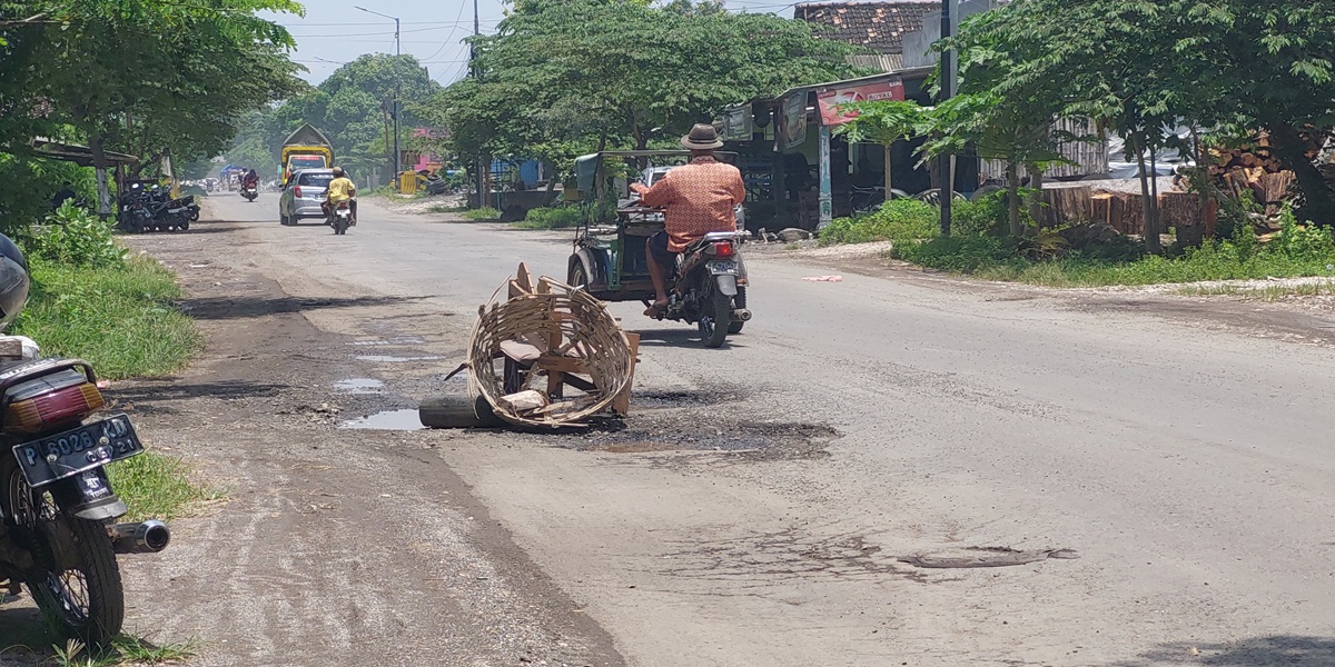 DIPASANG RAMBU KURSI: Membahayakan pengguna jalan, warga sekitar memasang rambu dari kursi diletakkan dijalan yang rusak agak tidak ada pengendara yang terjatuh.  