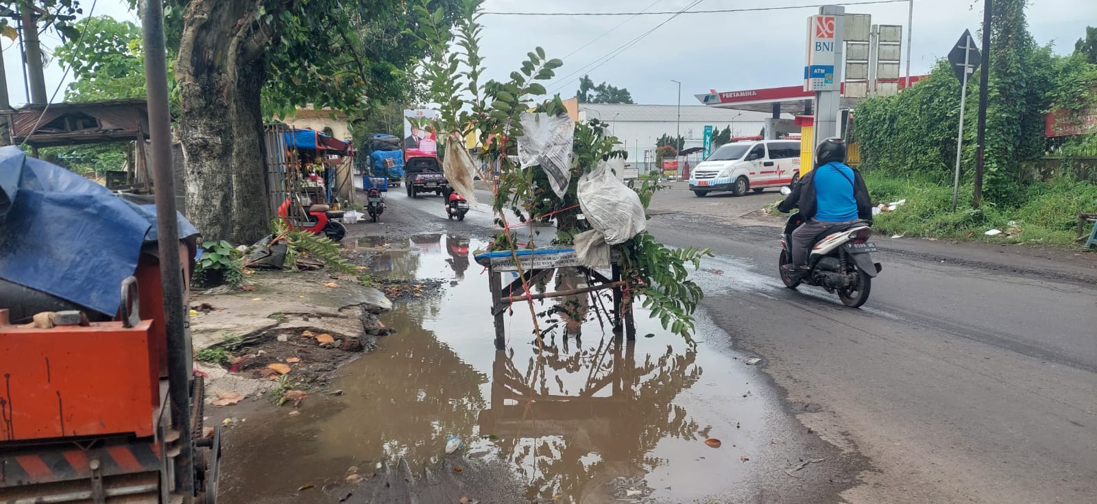 RAMBU POHON JAMBU: Untuk mengantisipasi terjadinya kecelakaan warga memasang rambu dijalan Oto Iskandardinata, mangli gunakan pohon jambu. (JUMAI/RJ)