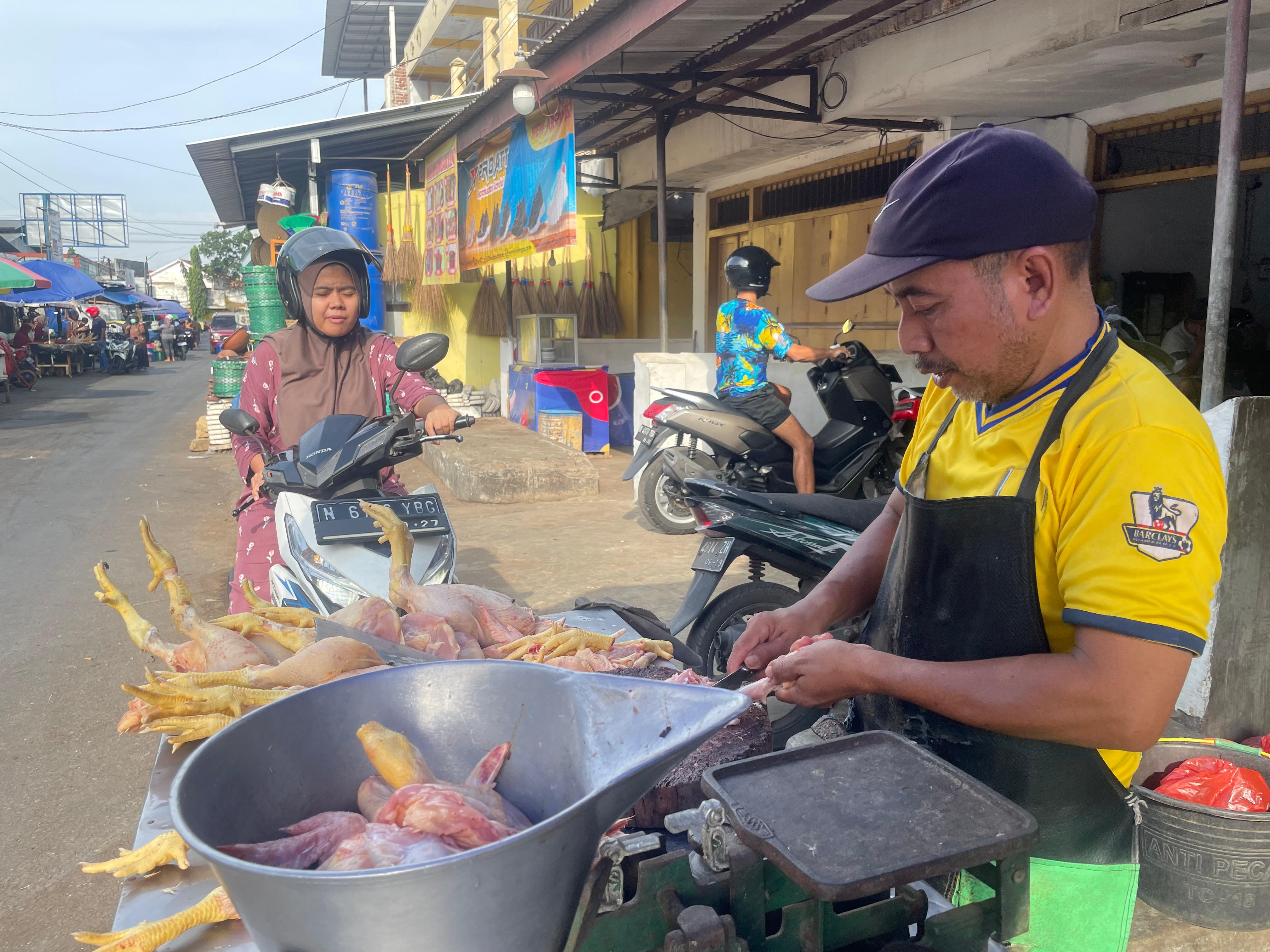 MENCEKIK: Salah satu pedagang daging ayam yang berjualan di Pasar Lumajang. Kini harga daging ayam mulai meroket.(ADE APRYANIS/RAME)