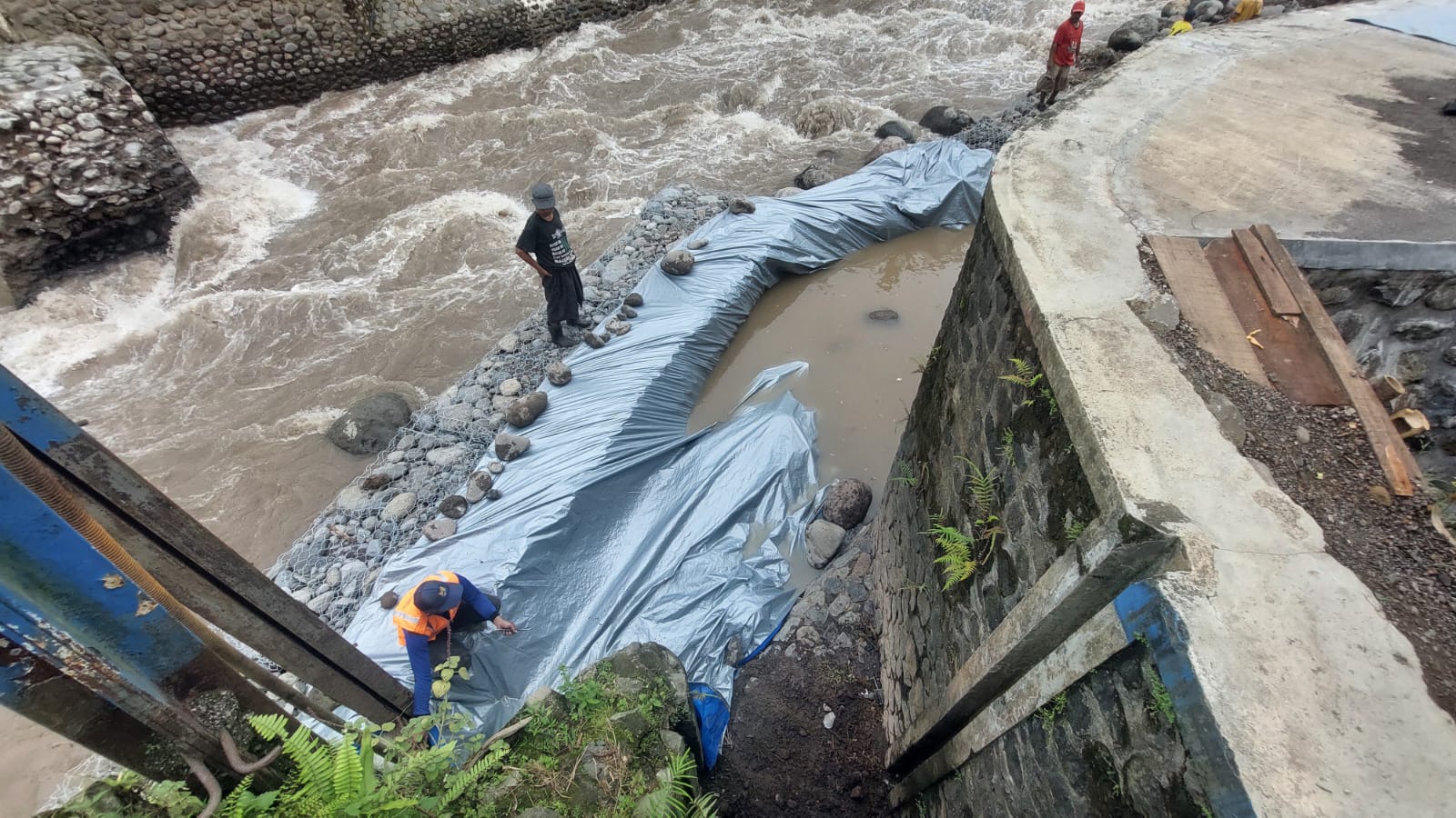 DIPASANG TERPAL: Setelah pasangan bronjong dibagian atasnya dipasang terpal, 98 hektar sawah bisa teraliri air yang dialirkan dari sungai Petung, Desa Pakis, Kecamatan Panti pada Jumat (13/2). (JUMAI)