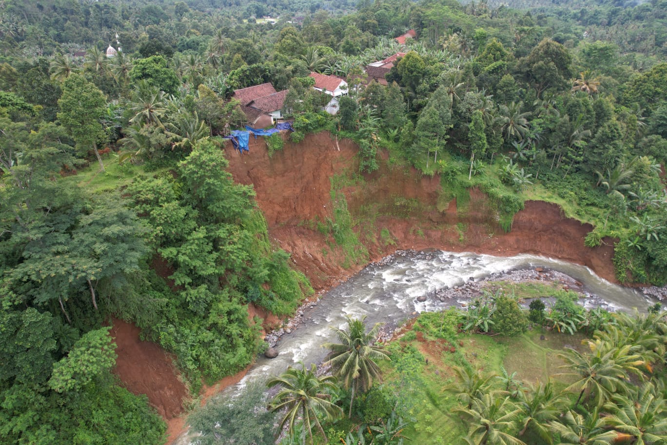 Titik longsor yang dipicu oleh gerusan aliran Sungai Kalijompo, tepatnya di Dusun Gendir, Desa Klungkung, Kecamatan Sukorambi, Jember. (Dok. BPBD Jember)