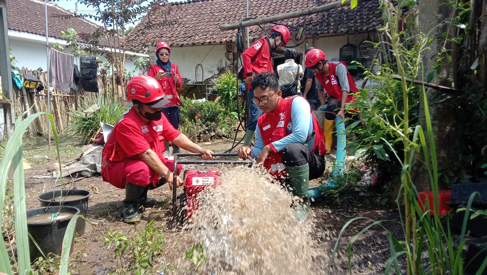 NORMALISASI: Relawan PMI Jember melakukan normalisasi sumur warga terdampak banjir di Desa Nogosari, Kecamatan Rambipuji. 