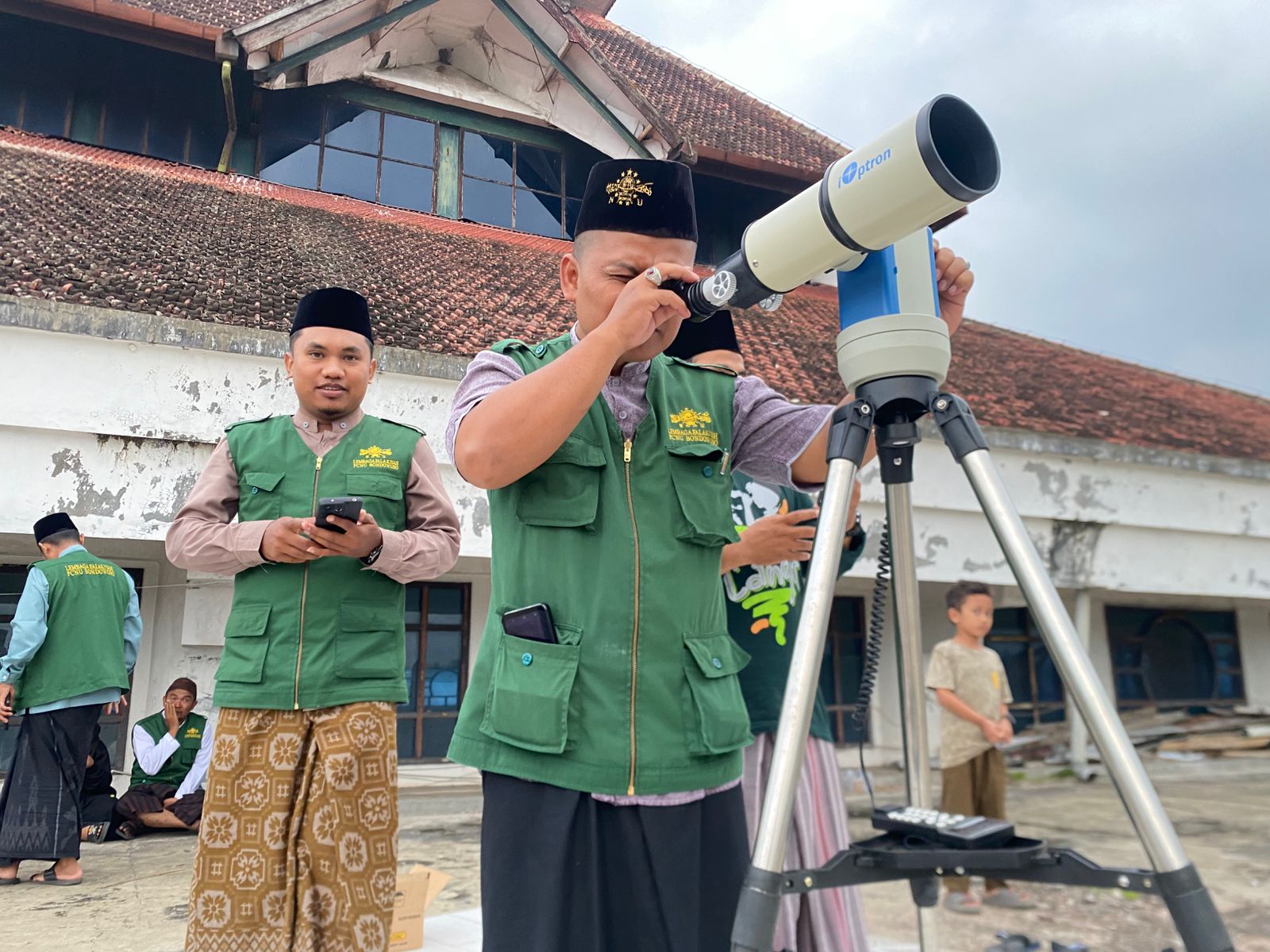 SERIUS: Anggota Lembaga Falakiyah PCNU Bondowoso mencoba melihat hilal 1 Ramadan dari atas Masjid Agung At Taqwa.