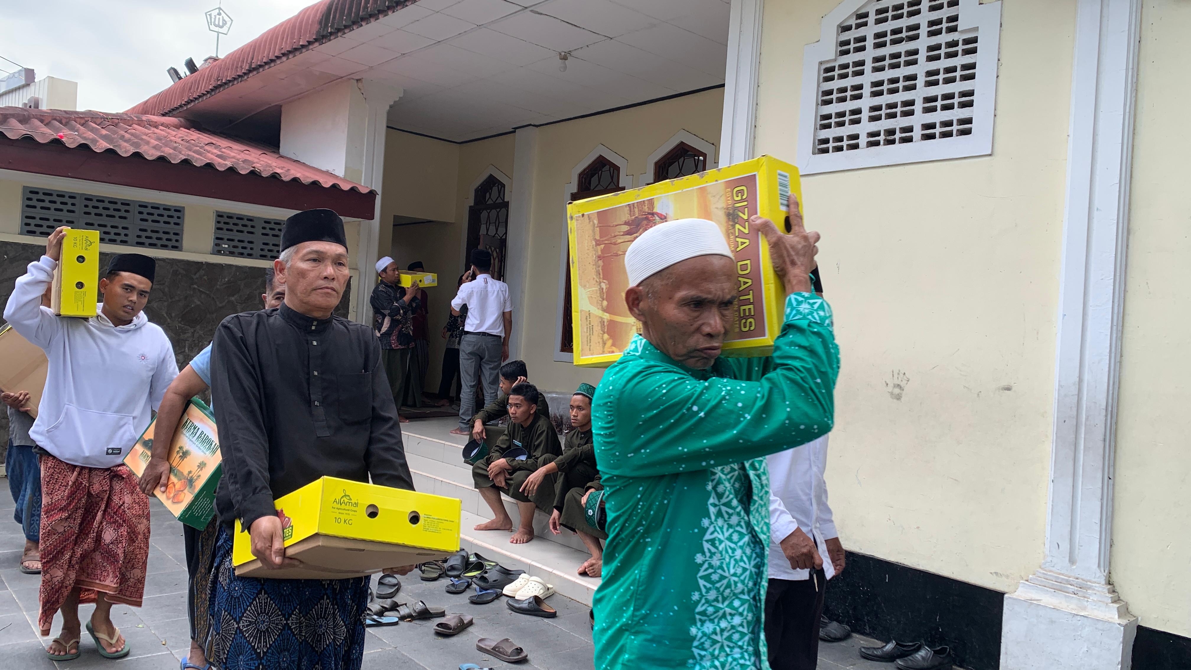 MERATA: Sejumlah penerima kurma dari Ponpes Al Ishlah Bondowoso, membawa kurmanya masing-masing.  