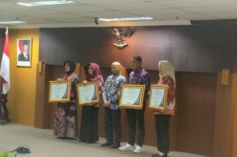 DIAKUI NASIONAL: Mewakili Bupati Gus Fawait, Kadiskominfo Regar Jeane, saat menerima penghargaan dari Ombudsman RI, di ruang Binaloka Adhikara, Surabaya, (19/2). (KOMINFO JEMBER)