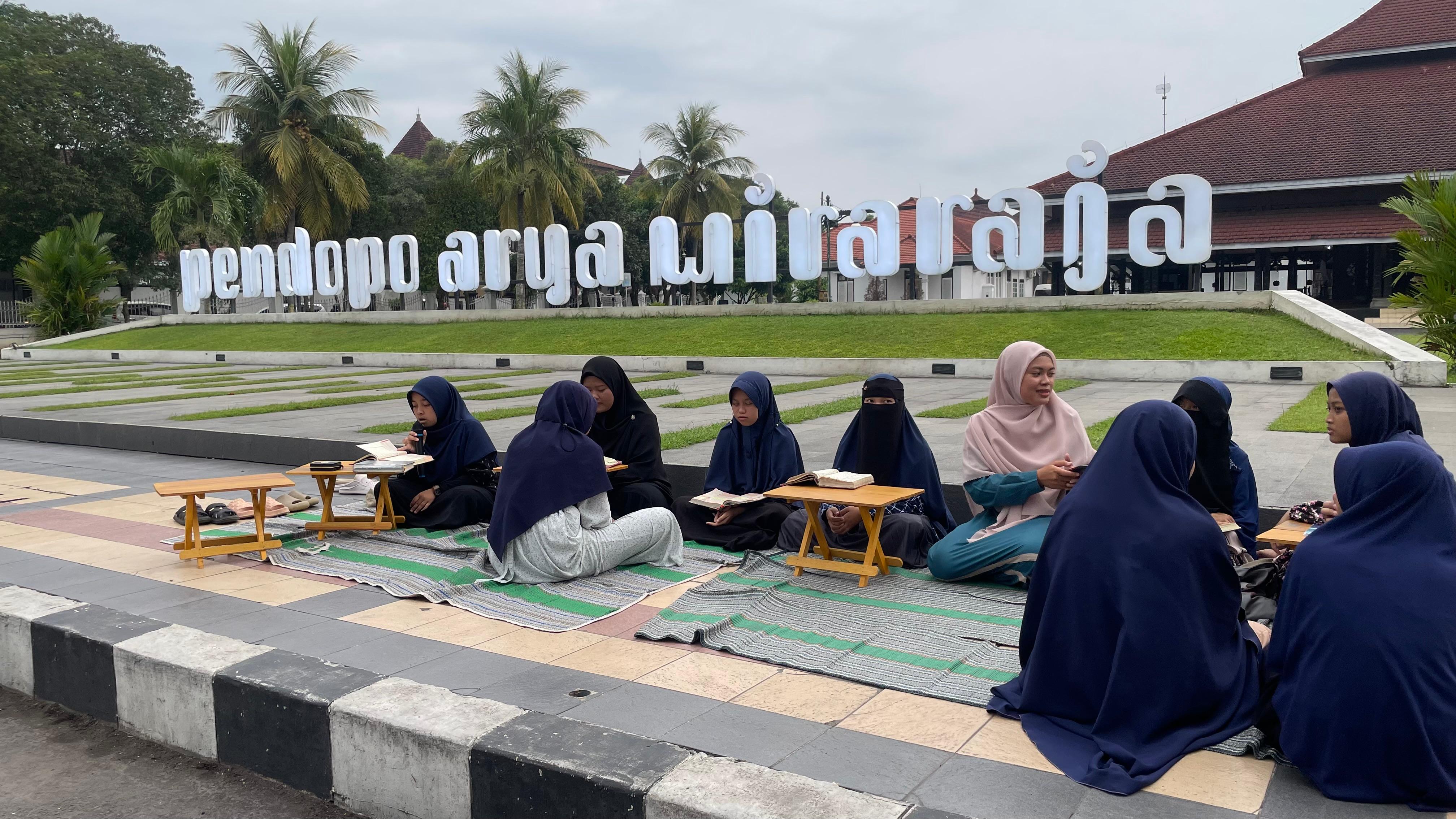 RUTIN: Santri Pondok Pesantren (Ponpes) Bahrusyifa Lumajang mengisi waktu ngabuburit dengan mengaji di pinggir jalan, kemarin.(ADE APRYANIS/RAME)