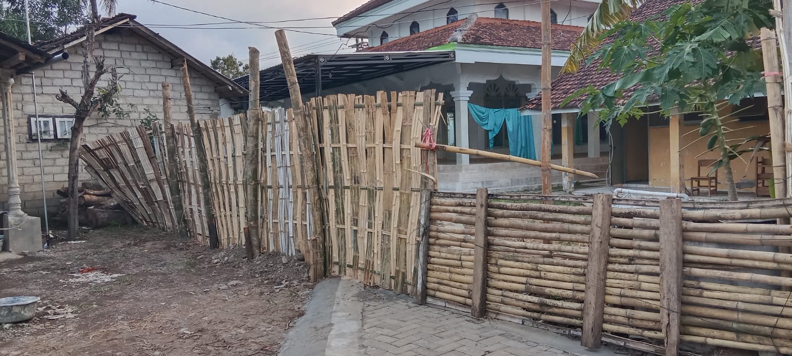 LEWAT SAMPING: Jamaah yang hendak menunaikan ibadah salat di Masjid Nurul Iman terpaksa harus menorobos atau loncat di pagar bambu samping masjid.