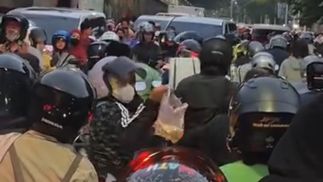 Pengendara motor saling berbagi makanan di waktu buka puasa saat terjebak macet. (Threads/prajnaparamithaa)