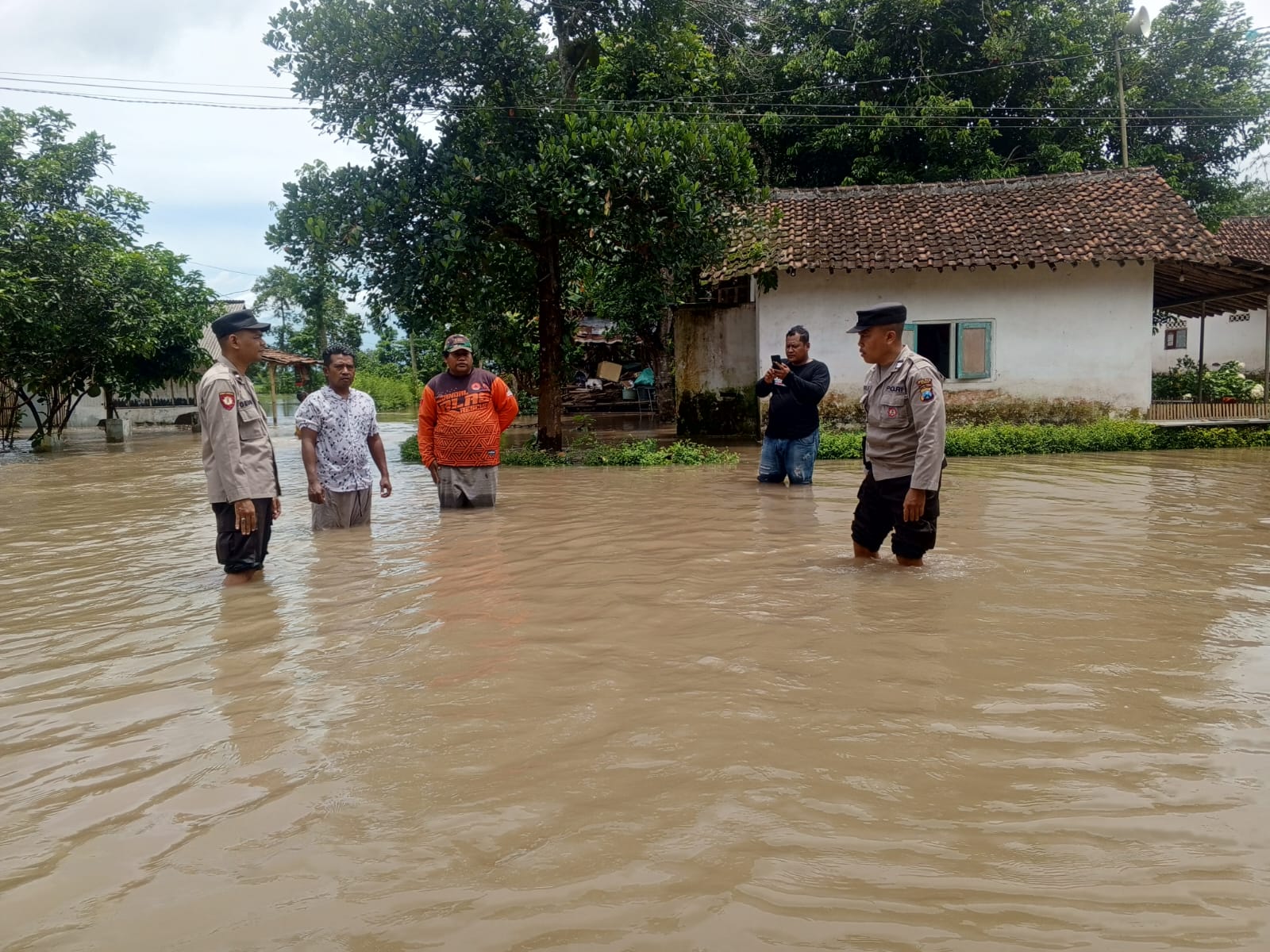 MASIH GENANGI JALAN: Kondisi air luapan dari sungai masih menggenangi jalan desa Dusun Sumberejo, Desa Glundengan, Kecamatan Wuluhan.  