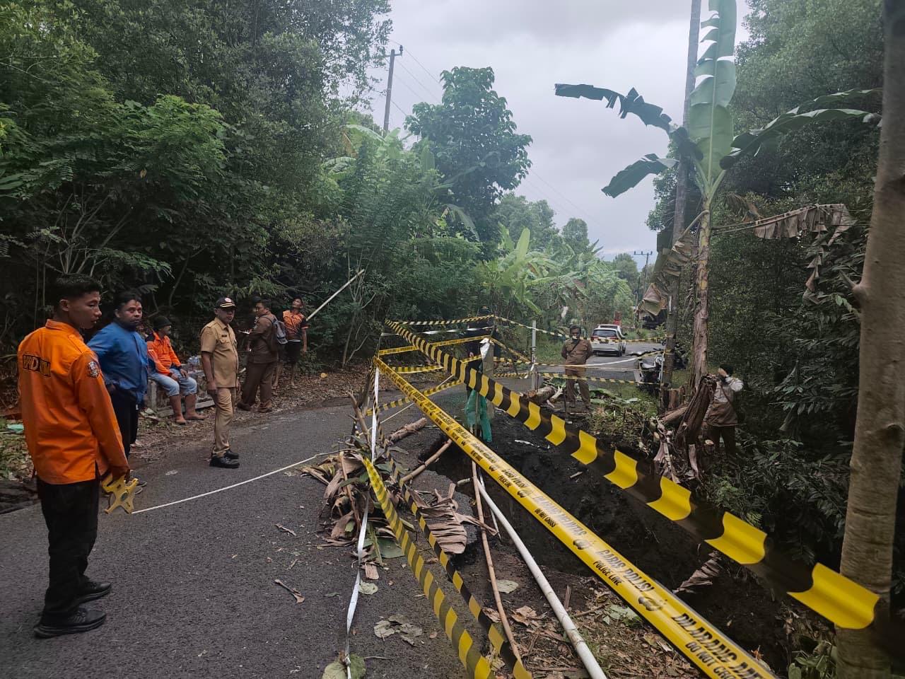 DICEK: Petugas BPBD Lumajang saat mengecek kondisi jalan yang longsor, kemarin.(BPBD FOR RAME) 