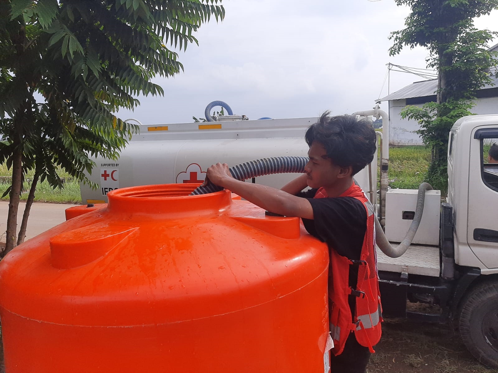 KEBUTUHAN PENTING:&nbsp;Petugas PMI Jember mengisi air bersih di tandon untuk warga terdampak banjir luapan Sungai Dinoyo di Dusun Krajan, Desa Gugut, Kecamatan Rambipuji.