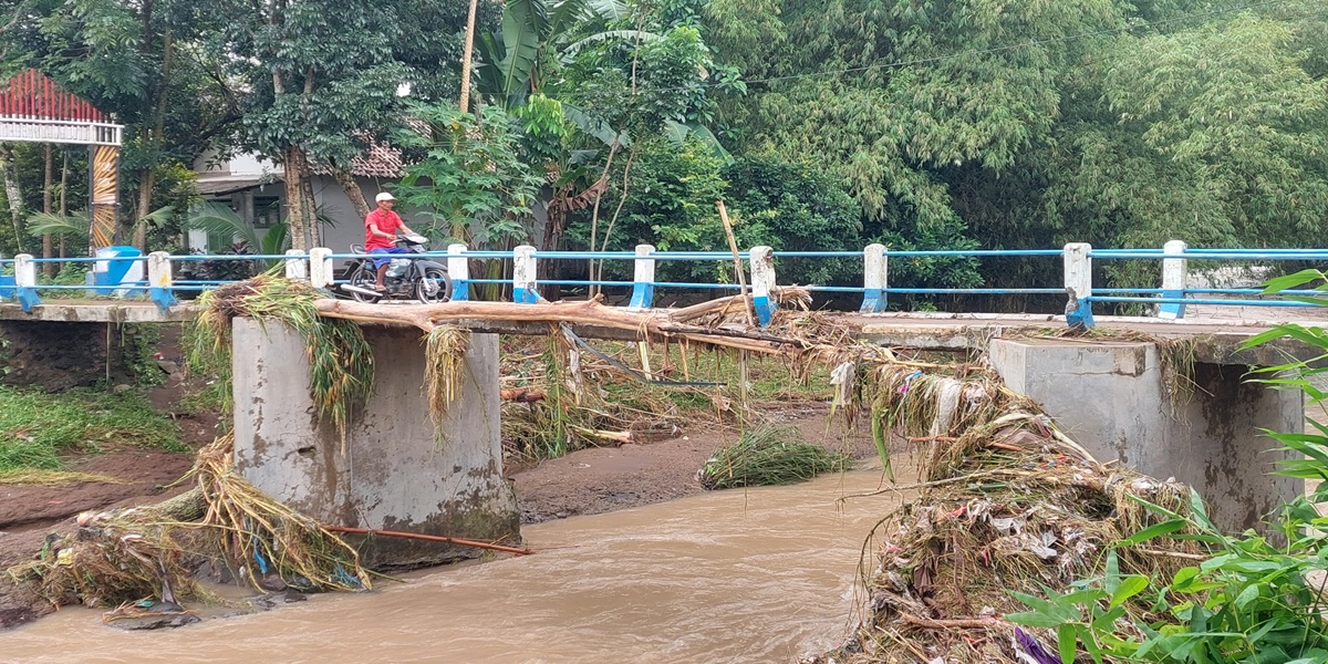 BEKAS BANJIR: Sampah kayu dari banjir luapan Sungai Dinoyo masih menghiasi jembatan penghubung antar dusun di Desa Gugut, Kecamatan Rambipuji, kemarin (3/3).