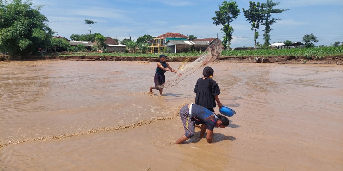 CARI IKAN: Warga Rambigundam mencari ikan di Sungai Dinoyo. (JUMAI/RJ)