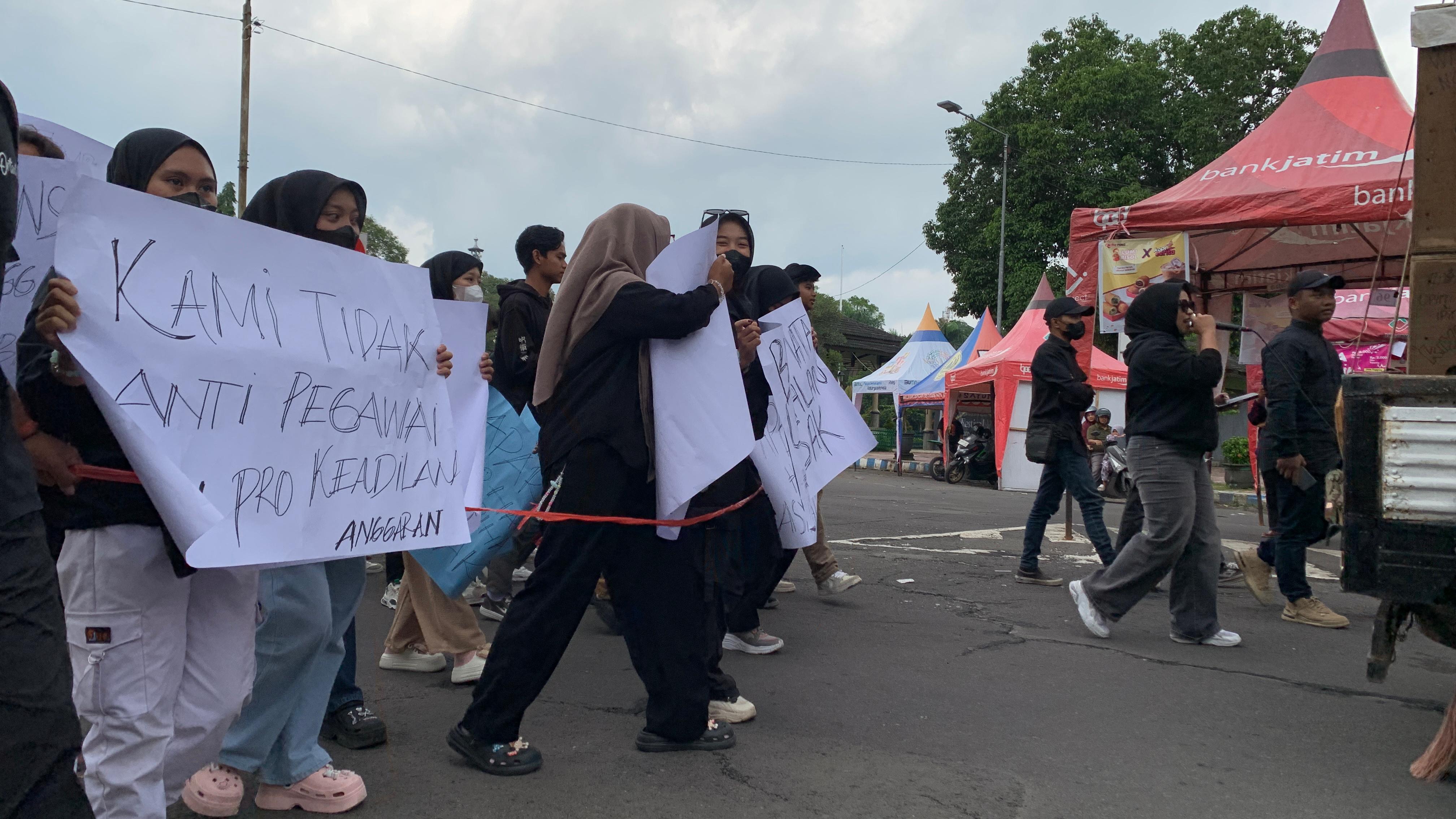 KOMPAK: Puluhan mahasiswa di Bondowoso membentangkan poster berisi tuntutan di depan Pemkab Bondowoso, tadi siang. (ILHAM/RJ)  