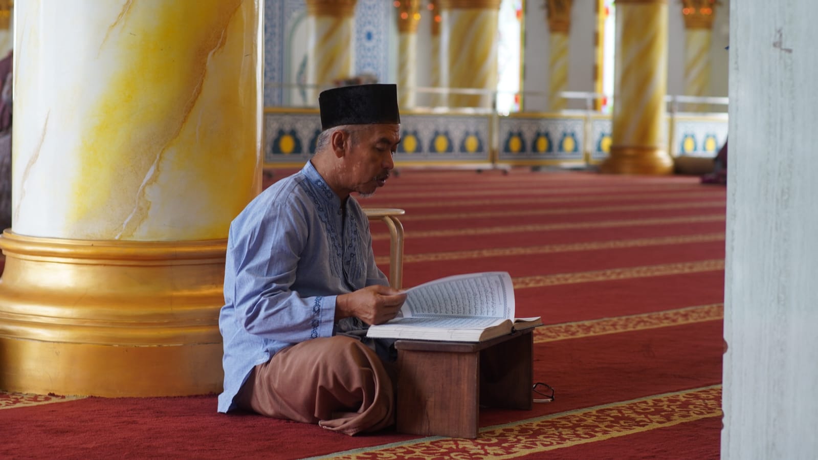 KHUSYUK: Meluangkan waktu sembari menunggu azan Magrib dengan membaca Alquran di Masjid Raudhotul Muchlisin.&nbsp;