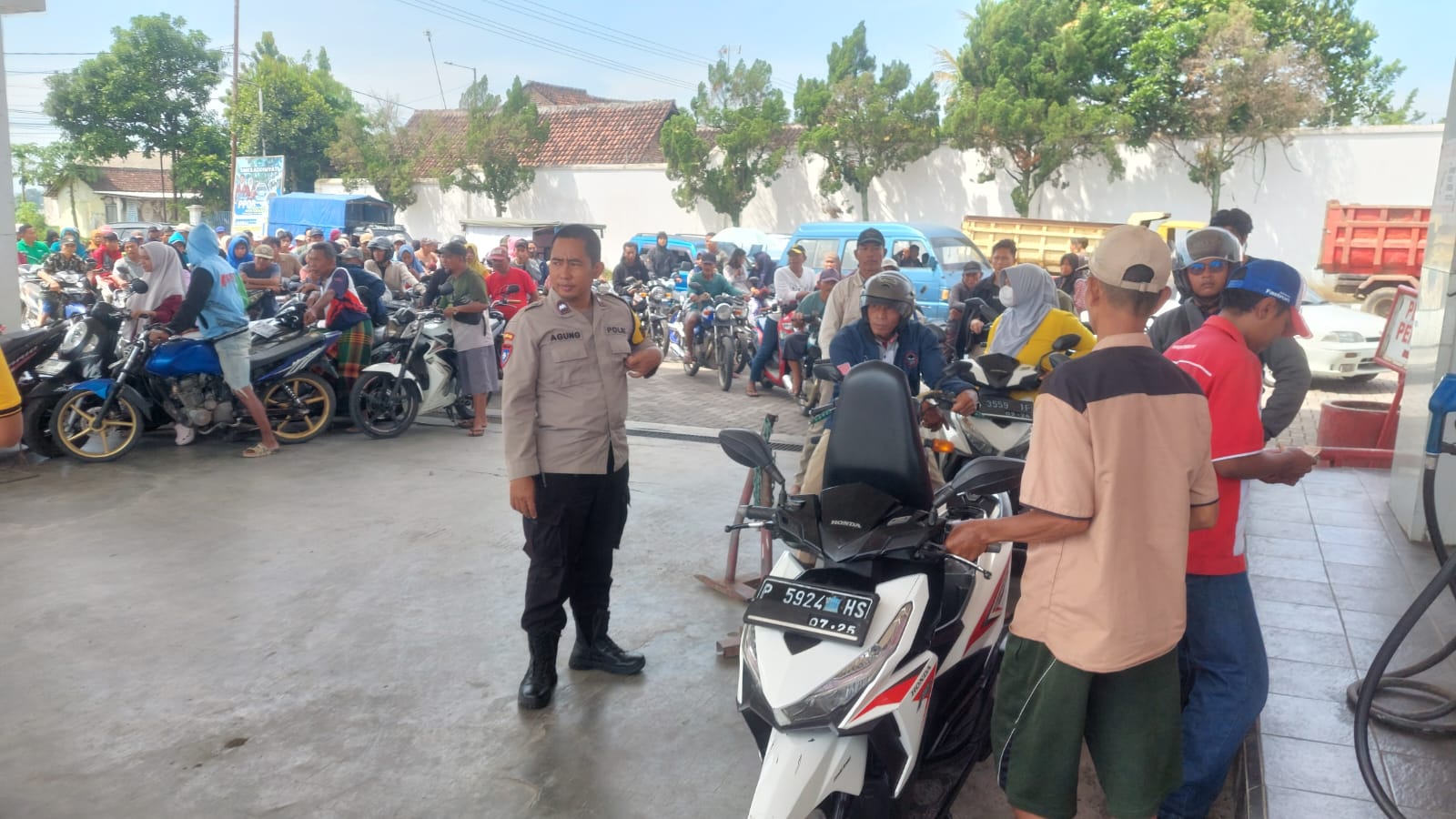 BERI HIMBAUAN: Anggota Polsek Jenggawah, Jember saat memberikan himbauan kepada warga dan pedagang bensin eceran di SPBU Jenggawah agar tidak panik dengan isu hoak tersebut