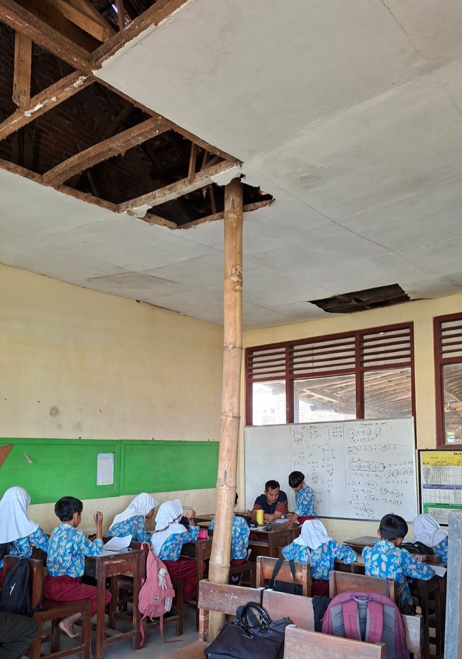 TAK LAYAK: Sejumlah siswa di Desa Kelabang, Kecamatan Tegal Ampel tetap belajar meski ruang kelasnya hampir ambruk.  