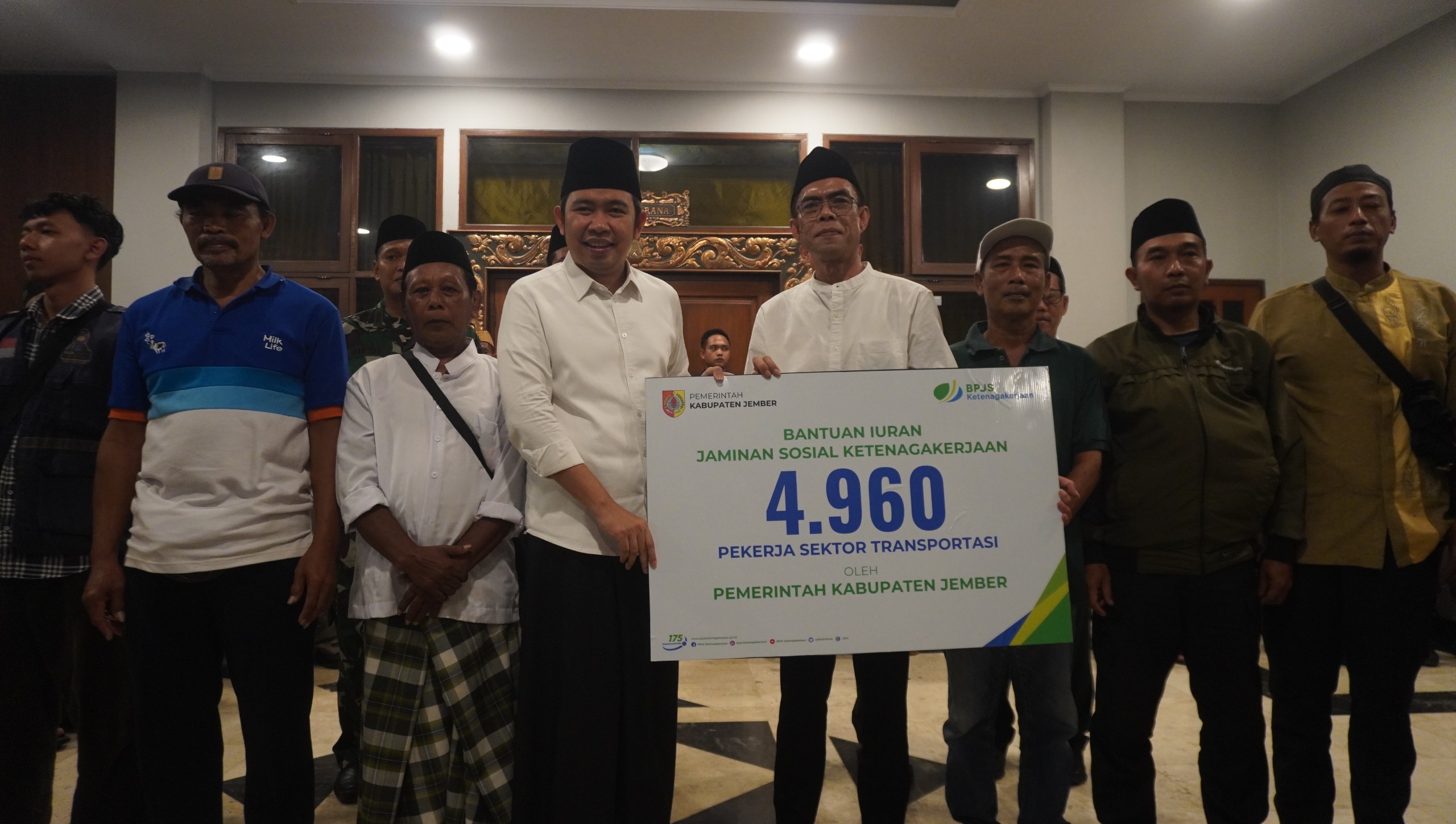 SERAH TERIMA: Bupati Jember Muhammad Fawait (empat kiri) dan Kepala Kantor BPJS Ketenagakerjaan Cabang Jember Dadang Komarudin (lima kiri) menyerahkan kartu bantuan Jamsostek secara simbolis 7/3/2026 
