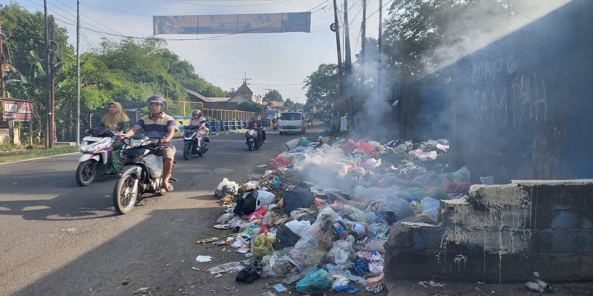 GANGGU PENGENDARA: Tumpukan sampah di transfer depo TPS Desa Tegalsari, Kecamatan Ambulu, mengeluarkan asap tebal setelah dibakar. (JUMAI) 