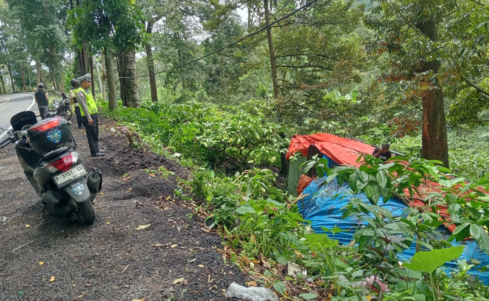 BUTUH EVAKUASI: Truk tronton bernopol L 8319 UV bermuatan the gelas terguling ke jurang di jalur Gumitir, kemarin (11/3).&nbsp;