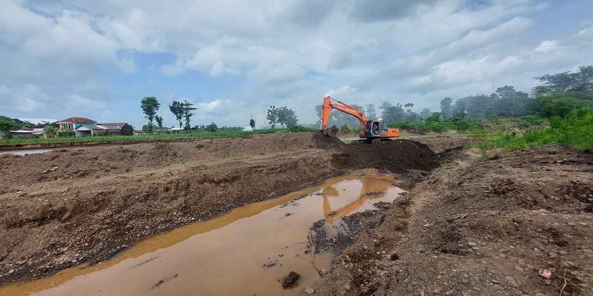 DINORMALISASI: Alat berat melakukan pengerukan Sungai Dinoyo di Dusun Krajan, Desa Gugut, Kecamatan Rambipuji, Selasa (10/3). Normalisasi dilakukan setelah sungai sempat meluap dan menggenangi puluhan