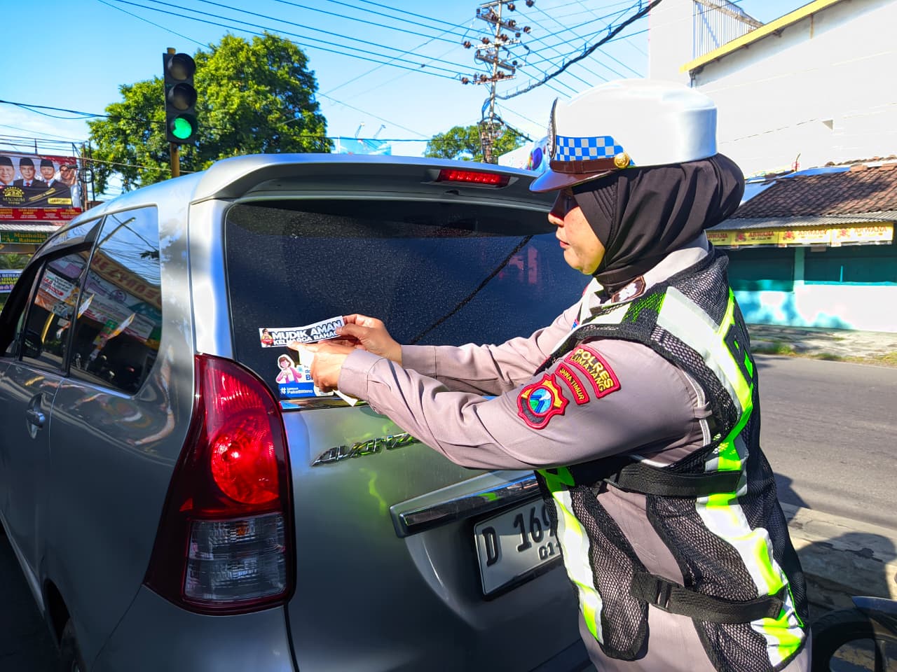 STIKER: Salah satu petugas kepolisian saat memasang stiker di sejumlah kendaraan, kemarin.(ATIEQSON MAR IQBAL/RAME) 